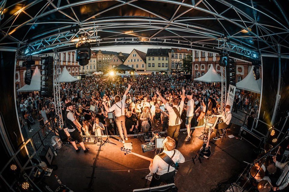 Die Bowtie Band auf einer Open-Air-Bühne vor großem Publikum