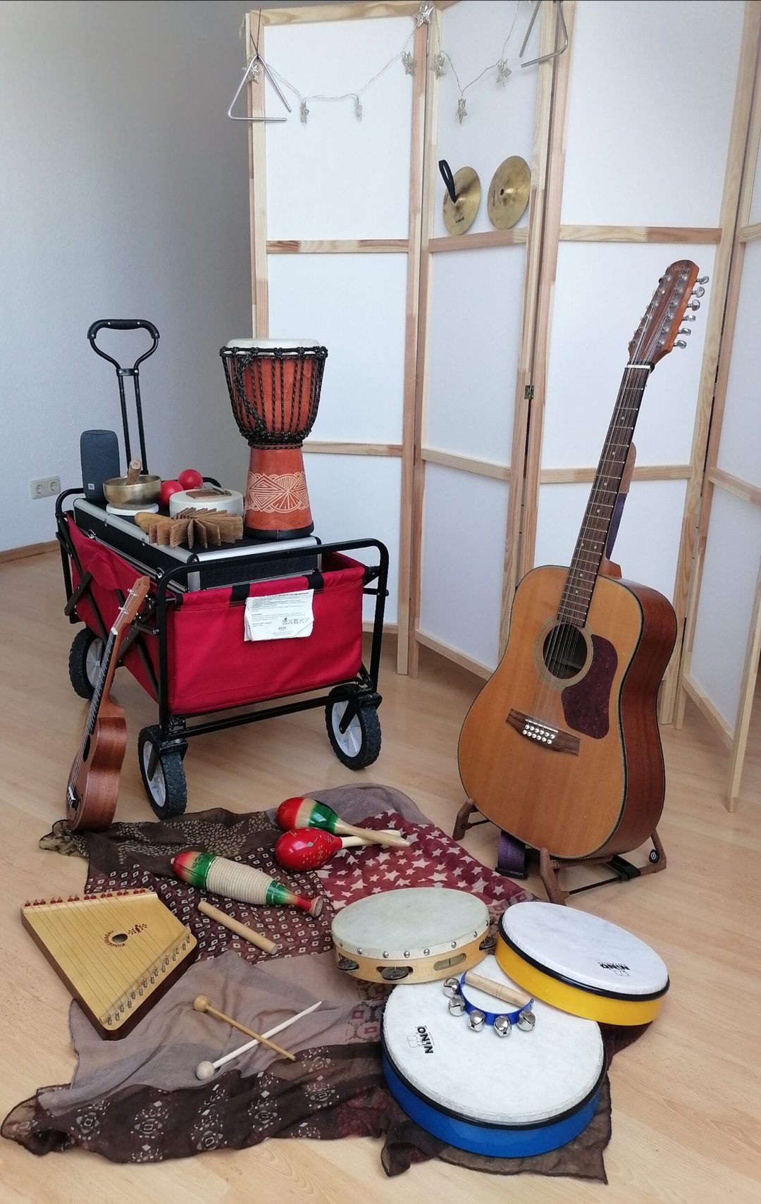 A handcart with instruments and a guitar for mobile music therapy