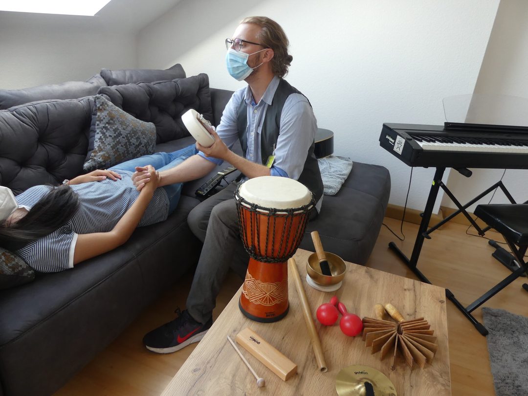 Music therapy: a client lying relaxed while the drum is played